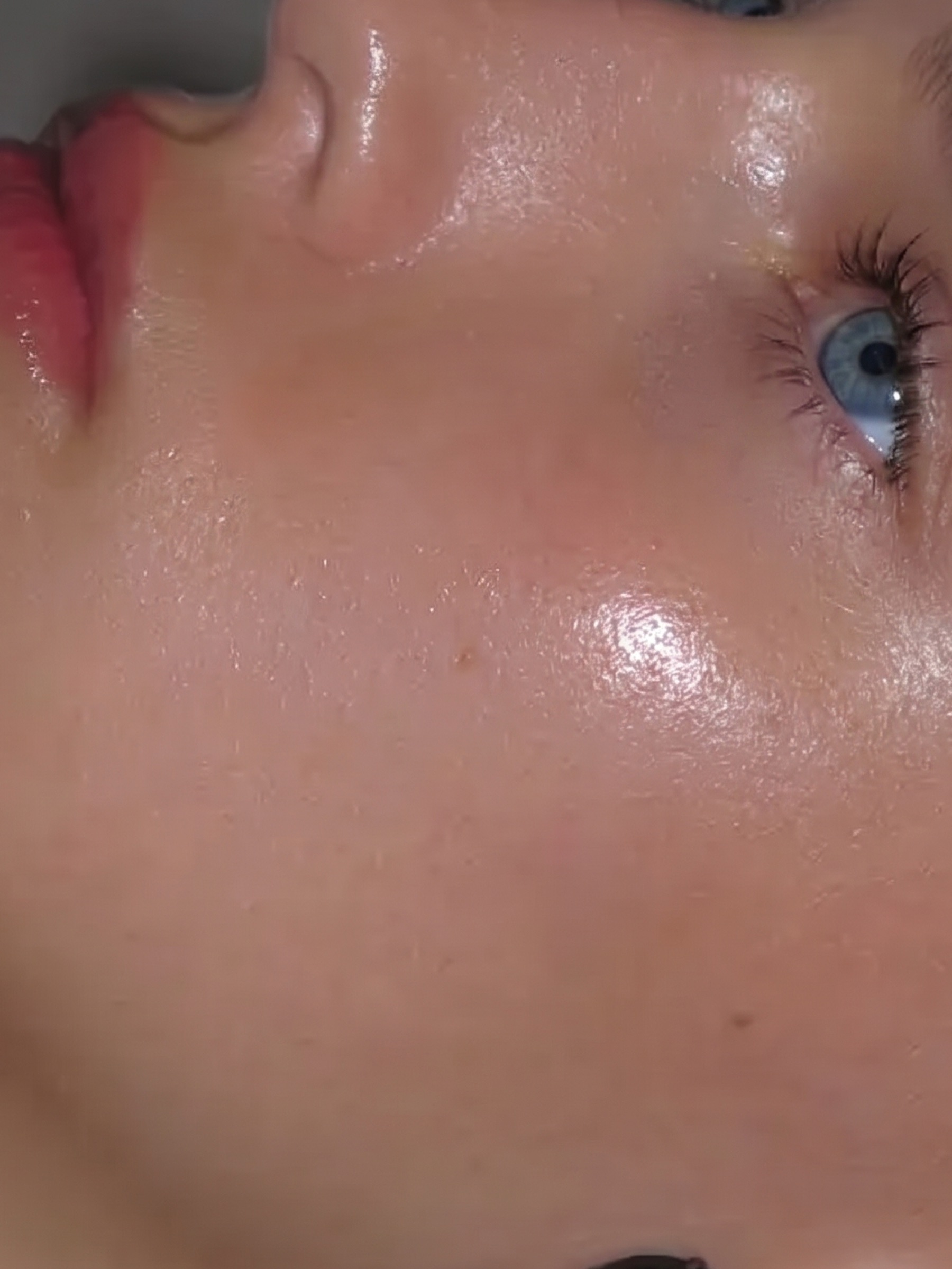 Extreme macro of lit skin across a cheekbone and eye.